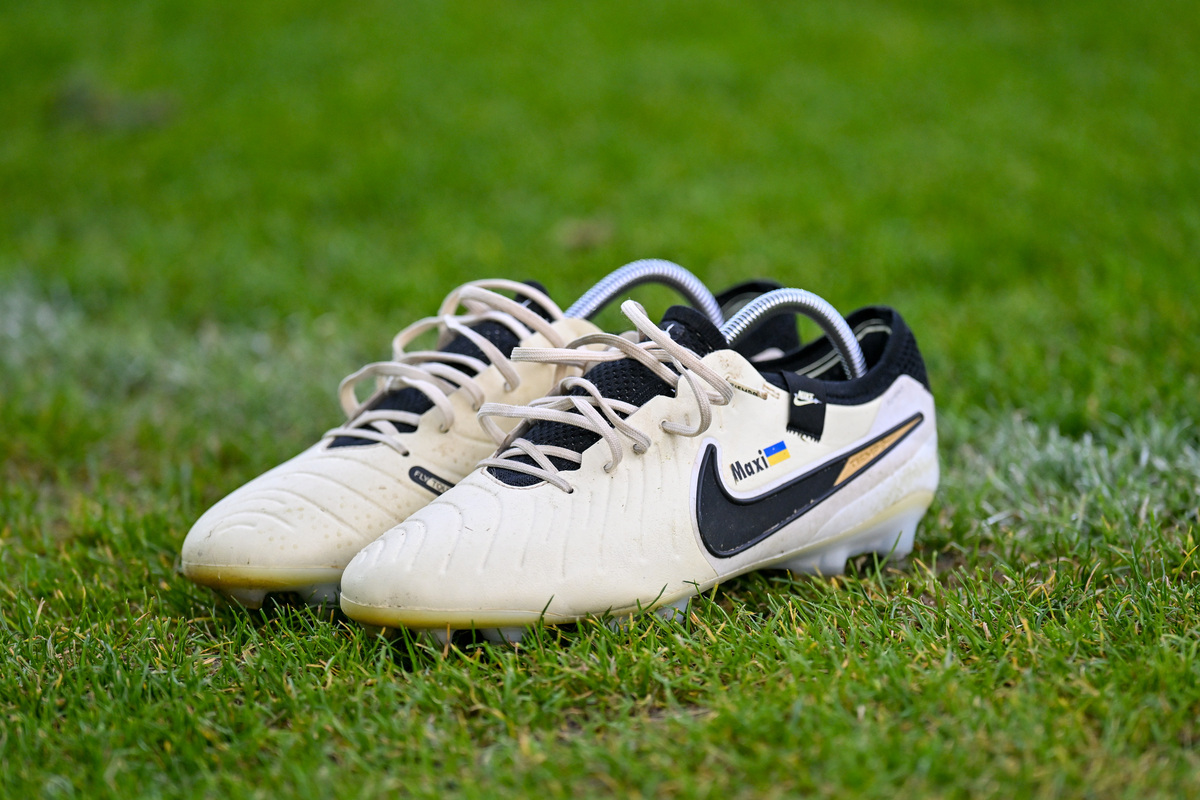 Weiß-Schwarze Fußballschuhe auf Rasen