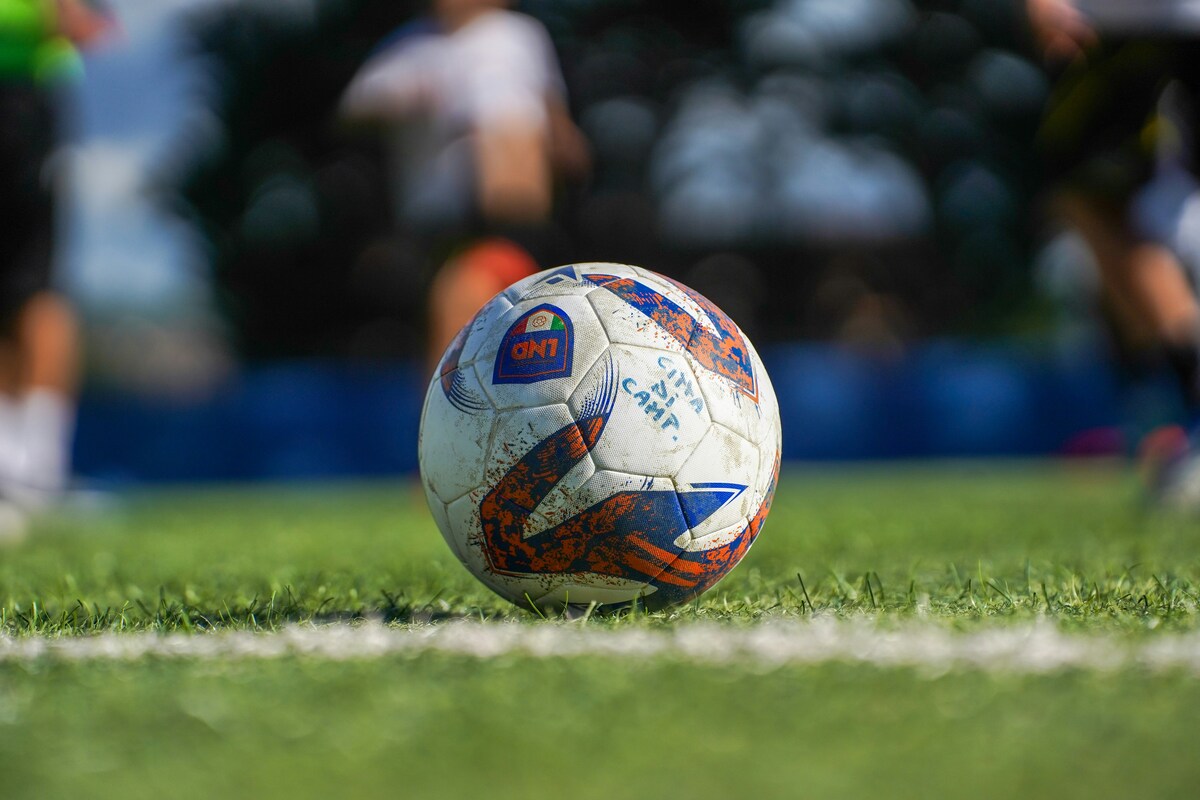 Wei&szlig;-Blau-Orangener Fu&szlig;ball auf Rasen