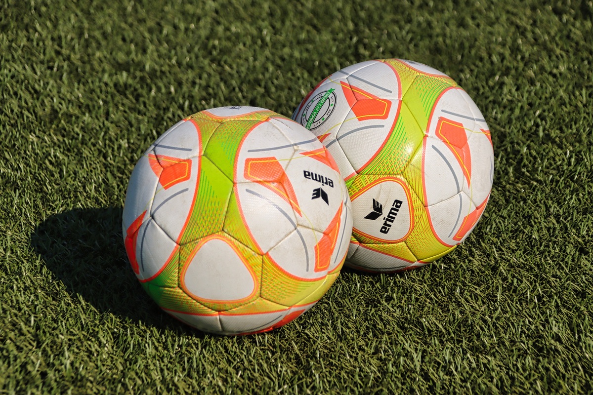 Zwei Fu&szlig;balle in Wei&szlig;-Orange-Gr&uuml;n