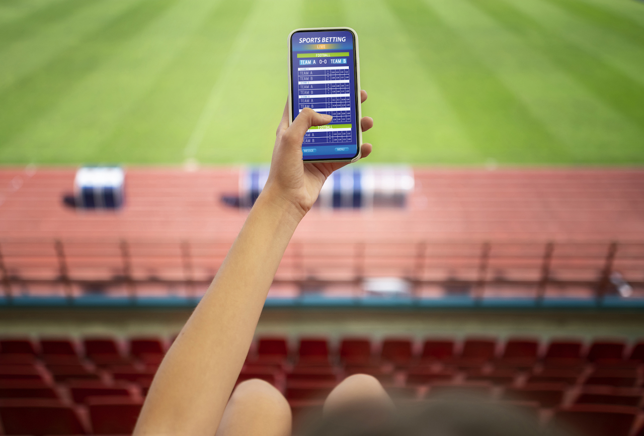 Frau im Stadion mit Smartphone